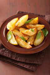 baked potato wedges in plate over brown rustic table