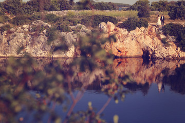 Bride and groom sitting on rocks