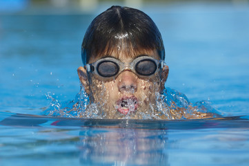 Fototapeta premium Child swimming in a pool