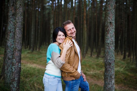 Happy couple in a pine forest