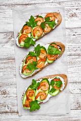 shrimp sandwich on a white wood background
