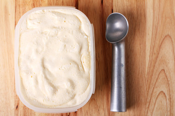 creamy vanilla ice cream in a white cup with a special spoon