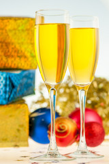 two glasses with champagne and Christmas gifts