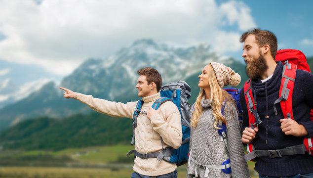 group of smiling friends with backpacks hiking