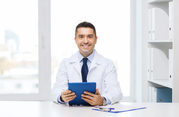 smiling male doctor in white coat with tablet pc