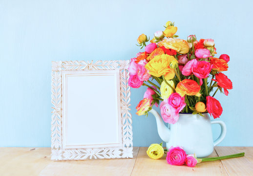 Summer bouquet of flowers and victorian frame on the wooden tabl