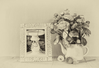 summer bouquet of flowers and victorian frame on the wooden tabl