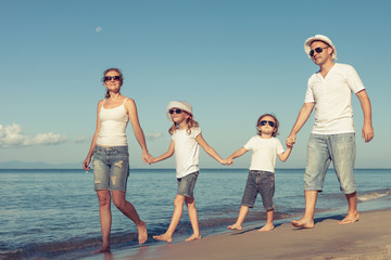 Happy family standing on the beach at the day time.
