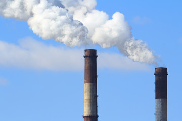 Industrial smoke from chimney on blue sky