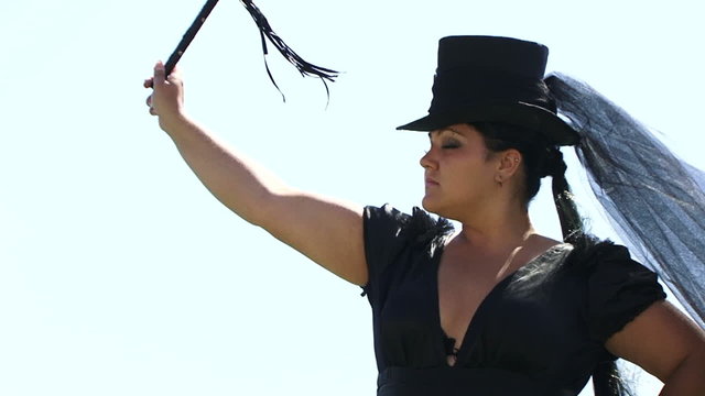 Woman In Black Swinging A Whip