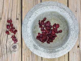 Dried cranberries in a rustic stone bowl