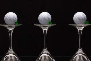 Three glasses of champagne and golf balls