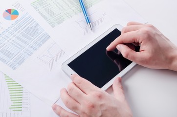Businessman working with digital tablet. Report charts on desk