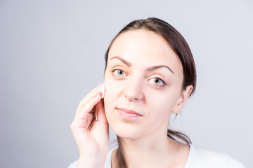 Girl Cleansing her Face Using Cotton with Cleanser