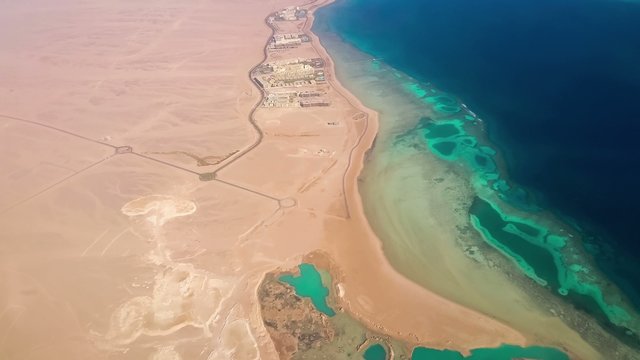 Aerial View from the Aircraft to Desert and Sea, sunny day
