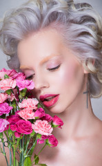 Beauty portrait of blonde pretty woman with flowers