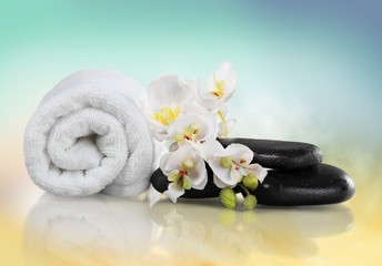 Fototapeta na wymiar Spa Treatment. Towel, gladiola and pebbles for massage