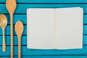 Notebook. Old recipe notebook, spoons on wood background