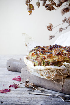 onions savoury cake on wooden cutting board with autumnal leaves