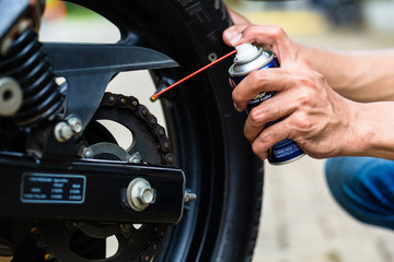 Man greasing motorcycle chain