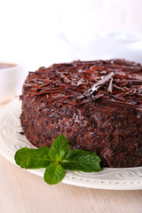Tasty chocolate cake with cup of tea on table close up