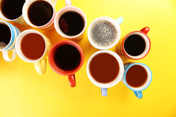 Many cups of coffee on color table, closeup