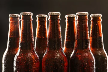 Fotobehang Bier Glazen flessen bier op donkere achtergrond