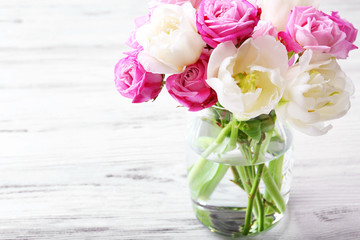 Bouquet of fresh roses and tulips on wooden background