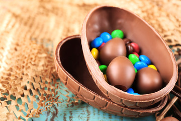 Chocolate Easter eggs on wooden table and wicker fabric,
