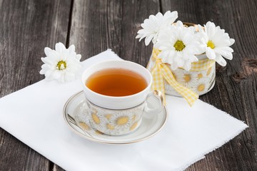 Cup of tea and white daisies