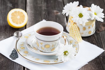 Cup of tea and white daisies