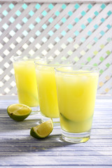 Glasses of cocktails on wooden lattice background