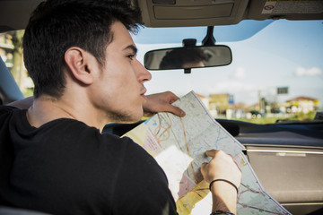 Gorgeous Young Man Inside Car Asking for Directions Holding a