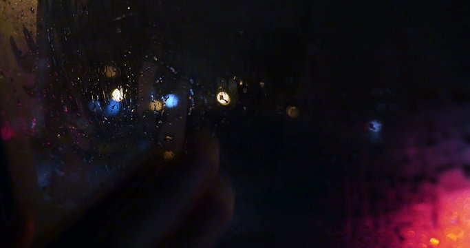 View of city through wet and weepeing car window