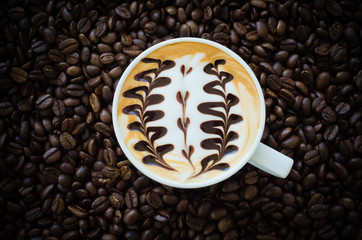 Closeup of a beautiful cup of  latte art on coffee bean backgrou