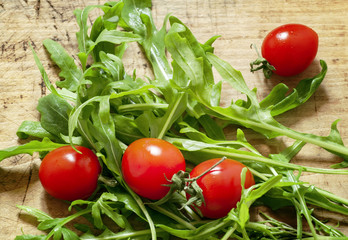 tomatoes on a wooden board with arugula