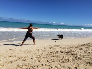 Woman doing yoga in the beach