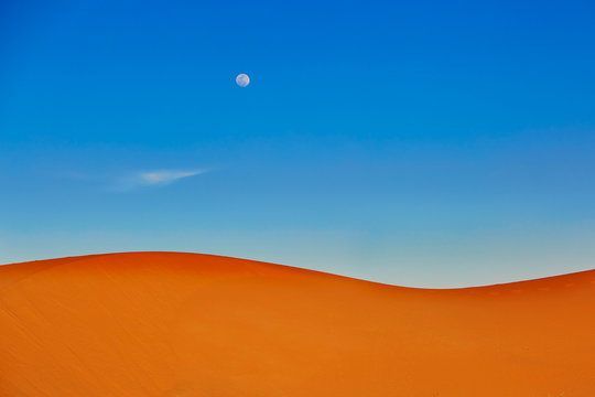 Sand dunes and almost full moon