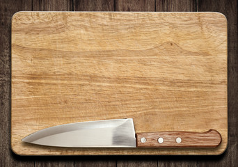 Cutting board and knife on old wood table