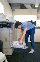 woman inserting paper in laser printer cartridge in office