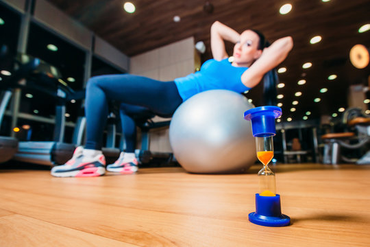 girl working out at gym with a ball,  in the foreground of an