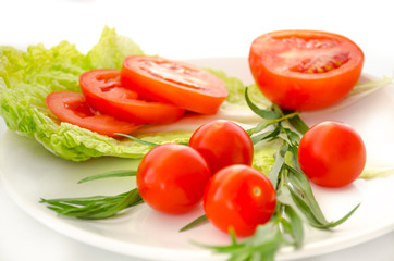 Tomatoes and salad leaves on the plate