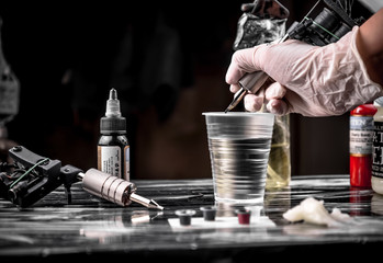 Hands of  tattooist create a tattoo