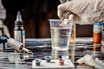 Tattoo master washes the machine