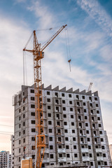 Crane and building construction site against blue sky