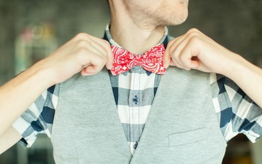 Young businessman in retro style correcting his bowtie