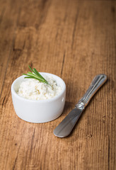 cream cheese in white bowl with knife