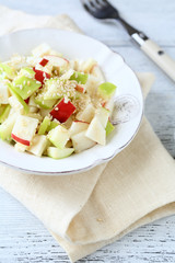 Salad with apples and celery on a white plate