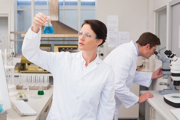 Fototapeta premium Scientists working with microscope and beaker