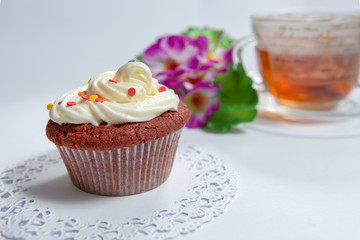 Sweet cake with cup of tea and flowers
